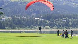 A paraglider comes in for a landing on the banks of Vangs Lake, Voss